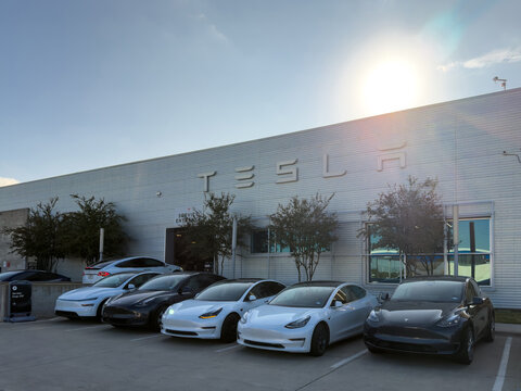 Dallas, Texas, USA - October 15th, 2026: Line of Tesla electric cars parked outside Service Entrance building in bright sunlight during day