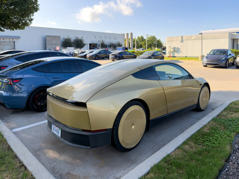 Dallas, Texas, USA - October 15th, 2026: Gold Tesla Cybercab autonomous robotaxi parked outdoors in Tesla service center vehicle parking lot
