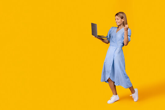 Happy Young Caucasian Woman Smiling While Using Laptop, Celebrating Achievement In Modern Office Setting. Positive Vibe Representing Business Success And Digital Lifestyle Concept.
