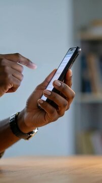 Vertical video: Seeing lit screen, male hands tapping phone at table to read texts, with watch cuff