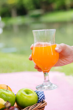 Vertical Picnic basket food bread fresh fruit coffee cup orange juice wood wicker box. Vertical Wheat bakery fruit food drinks green park outdoor lifestyle. Healthy appetizer box outdoors garden