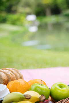 Vertical Picnic basket food bread fresh fruit coffee cup orange juice wood wicker box. Vertical Wheat bakery fruit food drinks green park outdoor lifestyle. Healthy appetizer box outdoors garden