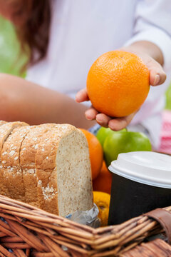 Vertical Picnic basket food bread fresh fruit coffee cup orange juice wood wicker box. Vertical Wheat bakery fruit food drinks green park outdoor lifestyle. Healthy appetizer box outdoors garden