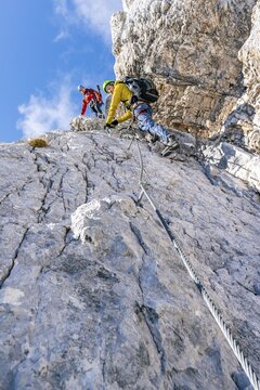 Two climbers on a via ferrata on a steep rock face, traversing Hohe Munde, Mieminger Kette, Tyrol, Austria