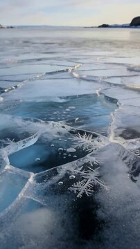 Vertical video: Panning camera across cracked clear ice at frozen bay showing hole, bubbles, frost
