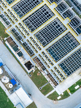 Aerial view of a modern water treatment plant featuring modular stainless steel tanks for flocculation, decantation, and filtration processes within an industrial facility.