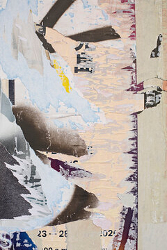 Abstract close-up of a textured paper  and torn posters with fragmented dark shapes with blue yellow detail