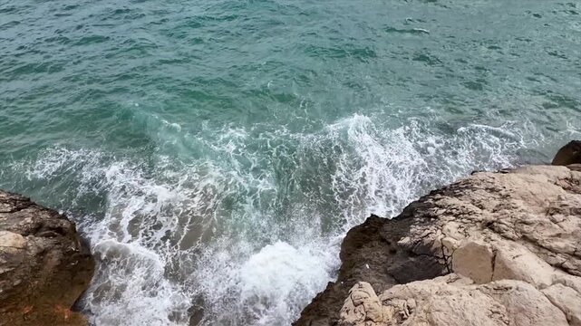 Overhead view of waves washing over rocks on the Barcelona coast