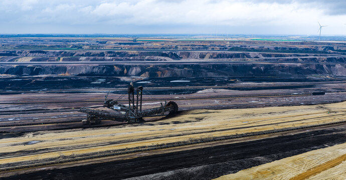 Aerial view of the Garzweiler surface mine with a massive bucket-wheel excavator operating in the vast open-pit coal mine in Juchen, North Rhine-Westphalia, Germany.