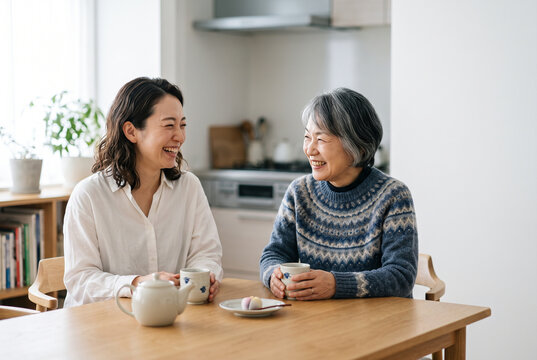 お茶を飲みながら笑顔で会話する母親と娘