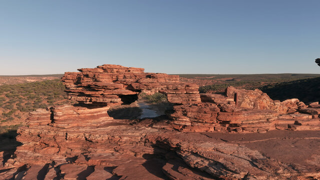 Aerial view of Nature's Window, a naturally formed sandstone arch overlooking the Murchison River gorge, surrounded by rugged rocky terrain in Kalbarri National Park, Western Australia, Australia.