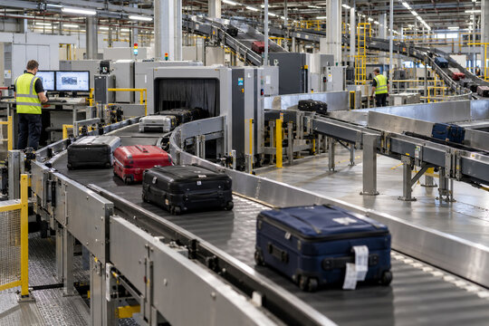 Airport Baggage Screening System with Suitcases on Conveyor Belts and Security Operators