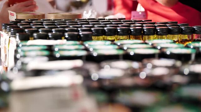 Rows of small oil bottles and glass jars displaying products at a market stall