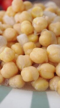 Cooked chickpeas soaking in liquid in a bowl on a table