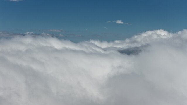 Aerial view of dense white clouds floating above the landscape near Sugarloaf, Colorado, United States.