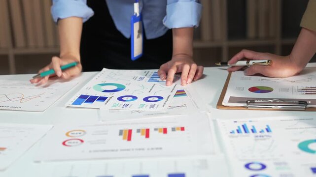 Business people analyzing financial charts and data on office table