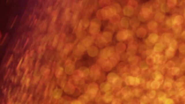 Shimmering dots. Hypnotic blur glow. Defocused color light transition rotate optic lens. Mystic bokeh orange yellow rays circles abstract background.