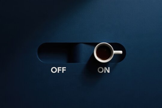 A coffee cup placed on a dark surface designed like a switch, toggled to "ON," with the words "OFF" and "ON" beside it.