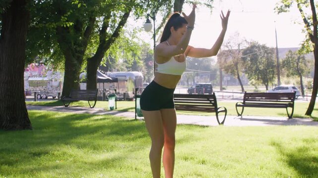 City yoga. Outdoor training. Slim female practicing healthy physical activity doing exercise in natural light green park.