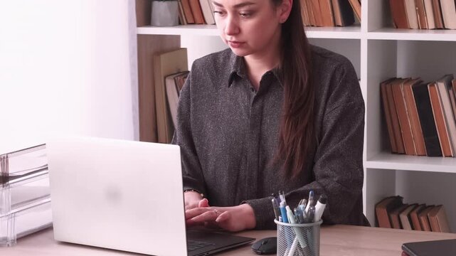 Manager lifestyle. Office atmosphere. Business woman drinking coffee typing laptop using notebook at desk at professional workplace.