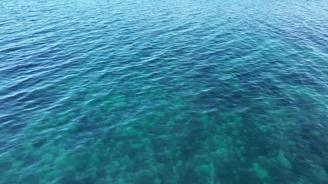 Top view of deep blue sea water surface with small ripples, aerial drone shot of turquoise ocean texture at island , abstract nature background	