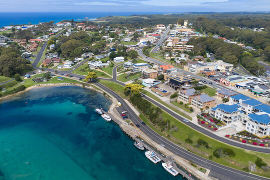 Aerial view of boats along a coastal estuary and city waterfront accommodation