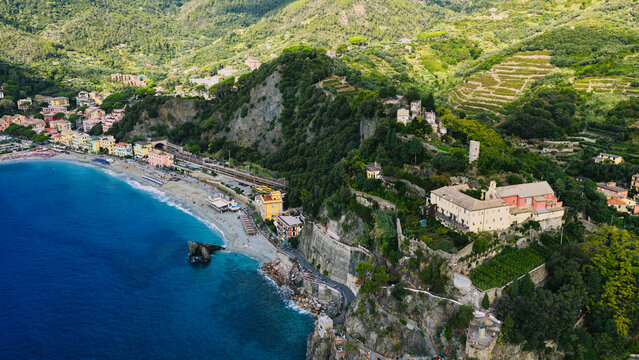 Aerial view of the coastal town of Monterosso al Mare with its sandy beach, historic buildings, and lush terraced hillsides along the Ligurian coast in Monterosso al Mare, Liguria, Italy.