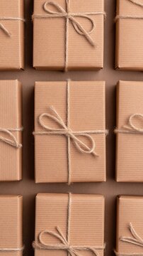 Recycled cardboard gift box tied with natural jute twine, arranged rows warm brown background, creating simple, sustainable holiday presentation