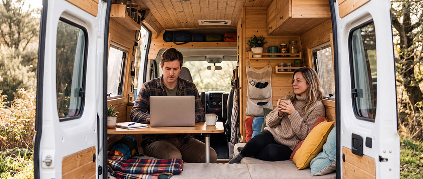Couple Working Remotely Inside Cozy Wooden Camper Van