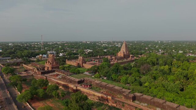 Aerial drone view of Brihadeeswara Temple (Thanjai Periya Kovil) complex featuring ancient Chola architecture stone towers and lush green surroundings in Thanjavur, Tamil Nadu, India