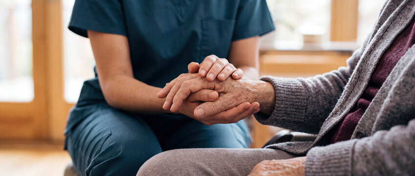 Healthcare Worker Holding Elderly Patient Hands with Compassion