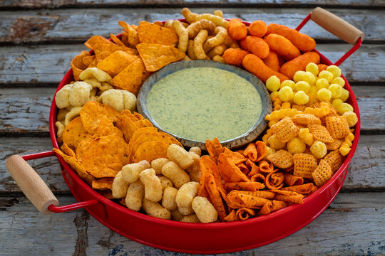 Group of salty snacks on the table, many bowls with different salty chips. 