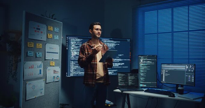 Confident Caucasian male engineer presents software strategy during late night work in office. Experienced tech consultant expertise, Innovative startup leader, Professional online conference concept.