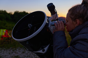 Amateur astronomer observing stars, planets, Moon and other celestial objects with a telescope in nature. © astrosystem