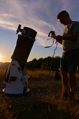Amateur astronomer preparing telescope during sunset for night observations of stars, Milky Way, Moon and Planets. © astrosystem