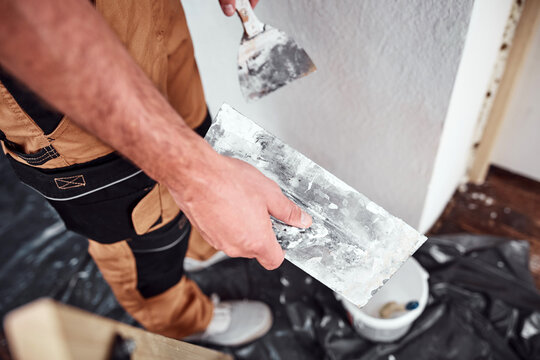 House painter putting skim coat and working on a home renovation.