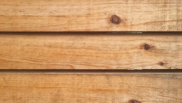 Wooden plank texture background with visible knots and parallel timber lines, ideal for fence mockups, rustic interior walls, and natural product backdrops
