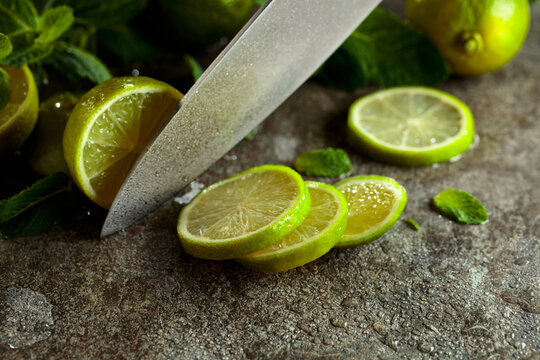 Knife, slices of lime and sprigs of fresh mint.