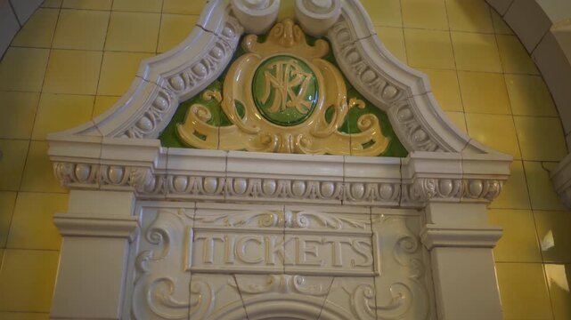 An ornate ceramic arch with a railway monogram and the word Tickets decorates the yellow tiled booking hall of Dunedin Railway Station, Static Shot