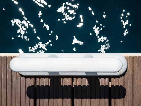 Top down view of mooring cleat on wooden pier dock with sparkling deep blue sea water background