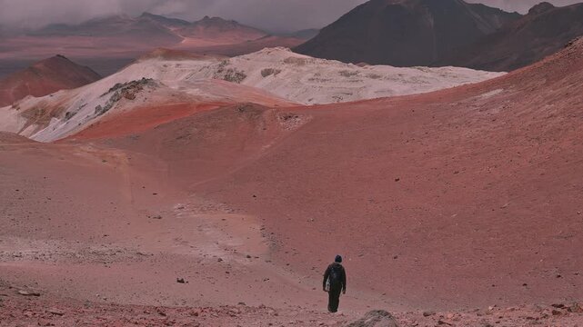 Hiker Descending Steep Red Volcanic Slope on the Cerro Toco Trail in the Atacama Desert, Chile   