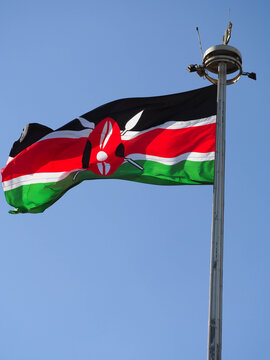 National Flag of Kenya Waving on Flagpole Against Blue Sky