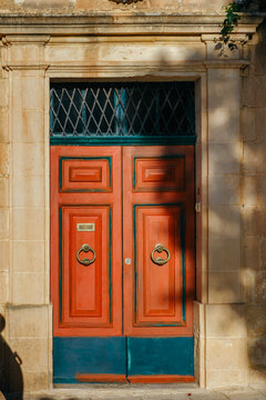 Terracotta Red and Teal Blue Wooden Front Door set in Ornamental Limestone Architrave