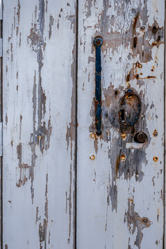 Rusting Iron Handle on Peeling White Painted Antique Wooden Door
