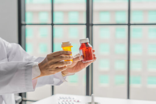 Mature Asian pharmacist show two medicine bottle