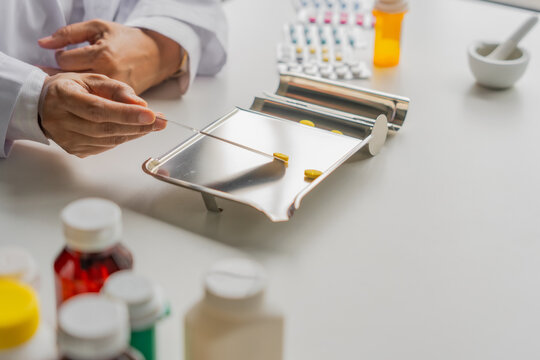  Mature Asian pharmacist using medication tray