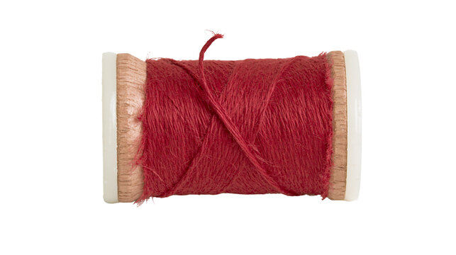 Deep red sewing thread wound on a small wooden spool