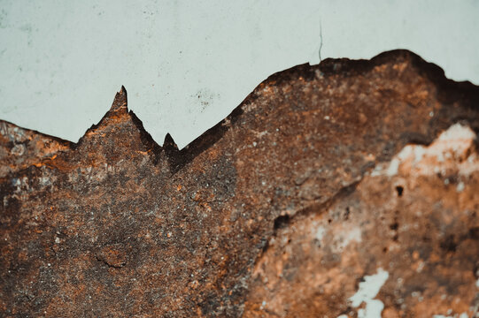 Macro texture shot of heavily corroded reddish-brown rusty metal surface with rough oxidized flaking. Ideal for industrial decay backgrounds, vintage texture overlays, metal corrosion studies, and rus