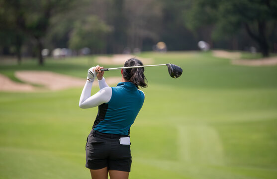 Professional woman golfer teeing golf in golf tournament competition at golf course for winner	
