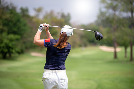 Professional woman golfer teeing golf in golf tournament competition at golf course for winner	